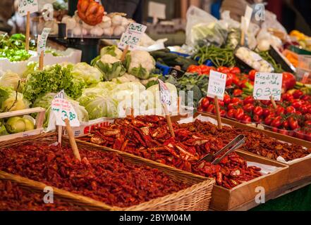 Nahaufnahme von getrockneten roten Paprika und anderem Obst und Gemüse mit Preistickets zum Verkauf im Mercato Rialto in Venedig, Italien Stockfoto