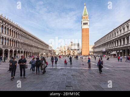 Markusplatz, Venedig, voller Menschen, die den Campanile und die Markusbasilika bei Sonnenschein unter blauem Himmel zeigen Stockfoto