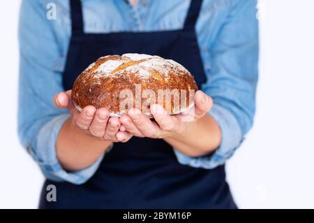 Frau hält in ihren Händen leckeres frisches, handgemachtes Brot in ihrem Haus, Nahaufnahme Stockfoto