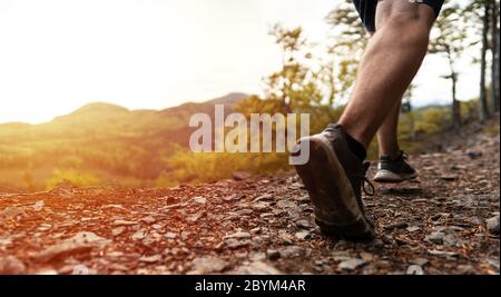 Nahaufnahme männlichen Läufer Beine, muskulös bauen Mann läuft schnell. Trail Runner läuft auf den Berg Stockfoto