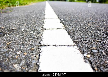 Oberfläche der Asphaltstraße weiße Linie Nahaufnahme Hintergrund Stockfoto
