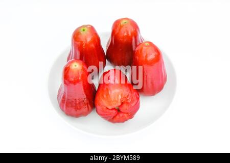 Rote Früchte, Rosenäpfel oder chompoo isoliert in Teller auf weißem Hintergrund Stockfoto