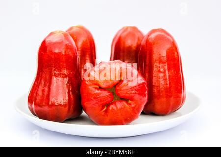 Rote Früchte, Rosenäpfel oder chompoo isoliert in Teller auf weißem Hintergrund Stockfoto