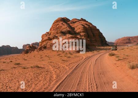 Fahren auf rauem Outback Schotter roten Sand Spur. Geländewagen mit Geländewagen, der Touristen auf Wüstensafari mit Dünen bringt. Wadi Rum Wüste in Jordanien Stockfoto