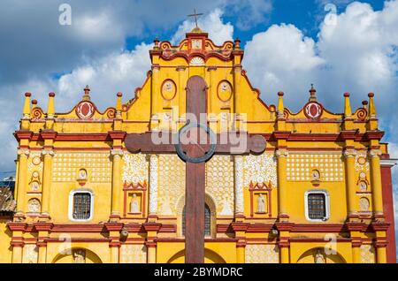 Fassade der Kathedrale von San Cristobal de las Casas mit einem Holzkreuz vor dem Gebäude, Chiapas, Mexiko. Konzentrieren Sie sich auf Kreuz, unscharfes Gebäude. Stockfoto