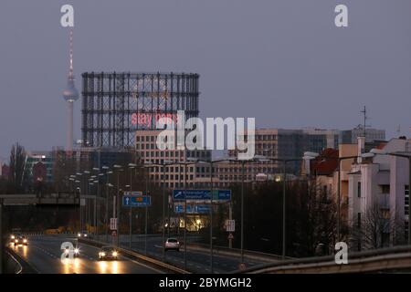 '02.04.2020, Berlin, Deutschland - Blick auf den Schöneberg-Gasometer mit dem Schriftzug 'Stay Home' und den Berliner Fernsehturm in der Abenddämmerung. 00S200402 Stockfoto