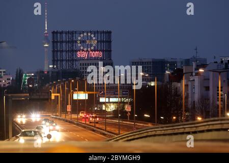 02.04.2020, Berlin, Deutschland - Blick auf das Schöneberg-Gasometer mit dem Schriftzug Stay Home und den Berliner Fernsehturm in der Abenddämmerung. 00S200402D009C Stockfoto