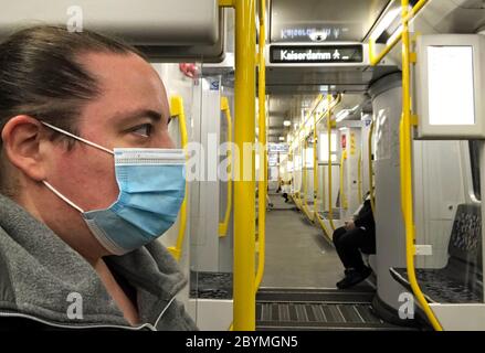 23.04.2020, Berlin, Deutschland - Frau in einer U-Bahn, die in Zeiten einer Corona-Pandemie Mund- und Nasenprotektor trägt. 00S200423D060CAROEX.JPG [MODELL RELEA Stockfoto