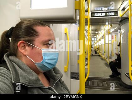 23.04.2020, Berlin, Deutschland - Frau in einer U-Bahn-Station trägt in Zeiten der Corona-Pandemie Mund- und Nasenprotektor. 00S200423D059CAROEX.JPG [M Stockfoto