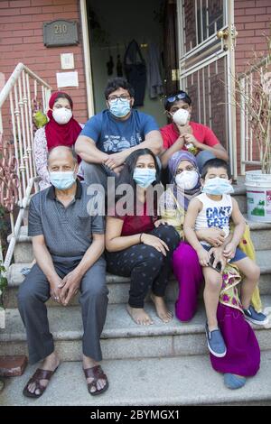 Während der Pandemie Covid-19 während des heiligen Monats Ramadan, steht die muslimische Familie aus Bangladesch auf der vorderen Treppe ihres Hauses. Brooklyn, New York. Stockfoto