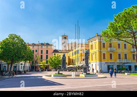 Desenzano del Garda, Italien, 11. September 2019: Märtyrer des Widerstands Denkmal auf der Piazza Cappelletti Platz und Glocke und Uhrenturm der Kathedrale Gebäude in der Altstadt, Lombardei Stockfoto