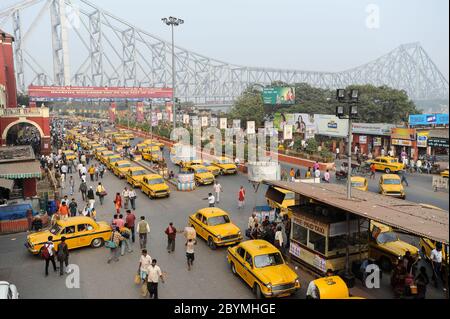 01.12.2011, Kalkutta, Westbengalen, Indien - ein erhöhter Blick auf die Howrah Brücke über den Hugli Fluss mit den berühmten gelben Taxis am Taxistand in Fr. Stockfoto