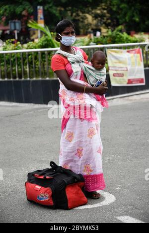 Guwahati, Assam, Indien. Juni 2020. Passagiere stehen mit ihrem Gepäck vor dem Bahnhof Guwahati in einer Schlange, um während der laufenden COVID-19-Sperre in Guwahati in einen Zug zu steigen. Die Zentralregierung hat drei Phasen der "Entsperrung" angekündigt, um die Beschränkung im Land inmitten der Coronavirus-Pandemie zu erleichtern, während die erste Phase am 30. Juni endet. Kredit: David Talukdar/ZUMA Wire/Alamy Live News Stockfoto