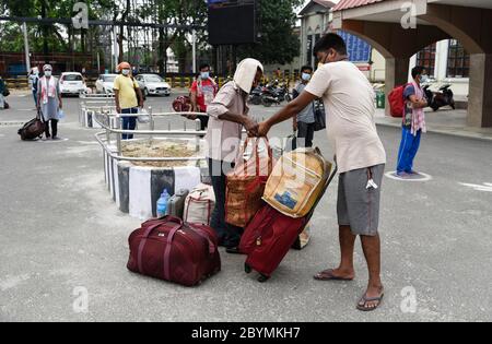 Guwahati, Assam, Indien. Juni 2020. Passagiere stehen mit ihrem Gepäck vor dem Bahnhof Guwahati in einer Schlange, um während der laufenden COVID-19-Sperre in Guwahati in einen Zug zu steigen. Die Zentralregierung hat drei Phasen der "Entsperrung" angekündigt, um die Beschränkung im Land inmitten der Coronavirus-Pandemie zu erleichtern, während die erste Phase am 30. Juni endet. Kredit: David Talukdar/ZUMA Wire/Alamy Live News Stockfoto