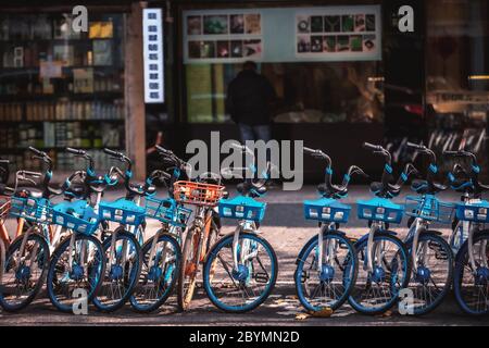 Vermietung von Elektrofahrrädern auf dem Bürgersteig, Hangzhou, China geparkt Stockfoto