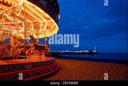 Eine Fahrt auf dem Messegelände am Strand mit dem Palace Pier. Die Stadt West Sussex Brighton am Meer. Das Messegelände, Bars, Clubs und Nachtleben machen die Stadt aus Stockfoto