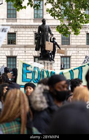 Ein Protestler steht auf dem Sockel einer Statue des Earl of Derby während eines Black Lives Matters Protestes, Parliament Square, London, 7. Juni 2020 Stockfoto