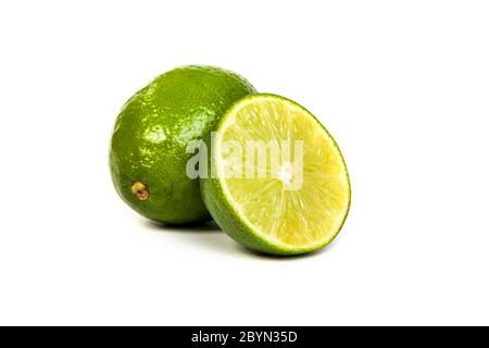 Eine ganze Limette und eine halbe Limette auf weiß Stockfoto