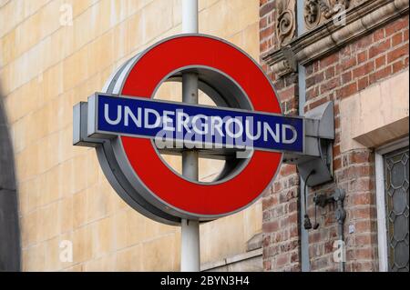 LONDON - 23. SEPTEMBER 2019: Schild an der U-Bahn-Station London an der Seite eines alten Backsteingebäudes Stockfoto