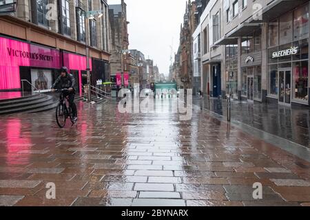 Glasgow, Schottland, Großbritannien. Juni 2020. Wetter in Großbritannien. Ein Radfahrer in starkem Regen in Buchanan Street während der Coronavirus Sperrung. Kredit: Skully/Alamy Live News Stockfoto