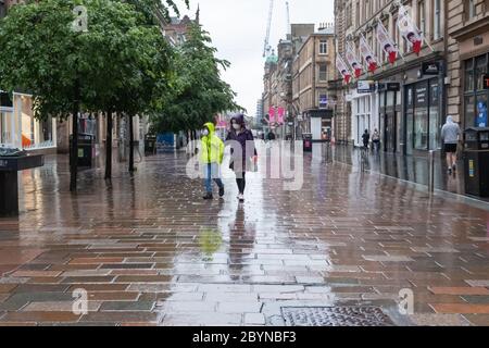 Glasgow, Schottland, Großbritannien. Juni 2020. Wetter in Großbritannien. Fußgänger bei starkem Regen in der Buchanan Street während der Sperrung des Coronavirus. Kredit: Skully/Alamy Live News Stockfoto