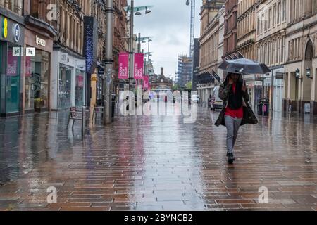 Glasgow, Schottland, Großbritannien. Juni 2020. Wetter in Großbritannien. Ein Fußgänger bei starkem Regen in der Buchanan Street während der Sperrung des Coronavirus. Kredit: Skully/Alamy Live News Stockfoto