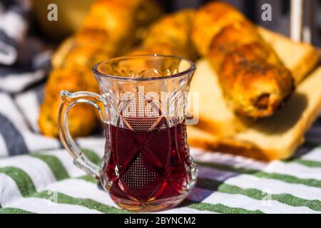 Rustikale Komposition mit traditionellem alkoholischen Getränk Kirschbrand in einer Glasschale. Stockfoto