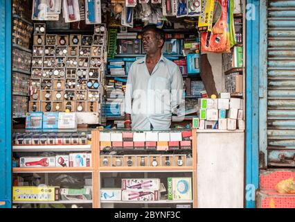 Chennai, Tamil Nadu, Indien - August 2018: Ein indischer Ladenbesitzer in einem Geschäft, das Armbanduhren und Schreibwaren verkauft. Stockfoto