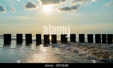 Wellenbrecher am Strand der polnischen Ostsee bei Rewal im Gegenlicht Stockfoto