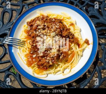 Italienische Küche Spaghetti Bolognese mit Hackfleisch und Tomatensauce mit Käse und schwarzem Pfeffer auf einer gegossenen Tischplatte Stockfoto