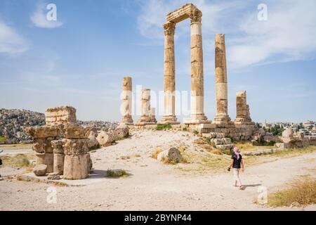 Junger Mann mit typischer Kopfbedeckung in Jordanien, der auf Ruinen des Herkules-Tempels auf dem Gipfel des Berges der Zitadelle von Amman steht. Stockfoto