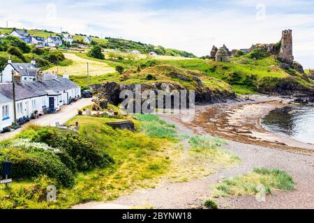 Ruinen von Dunure Castle aus dem 13. Jahrhundert, mit Blick auf den Firth of Clyde, und eine Reihe von Fischerhütten, Ayrshire, Schottland, Großbritannien Stockfoto