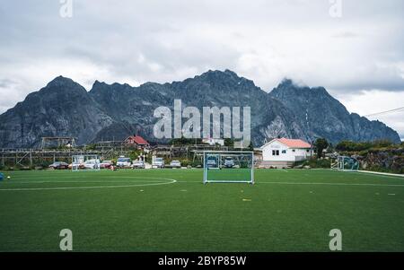 Leeres Trainingstor für klassischen Fotbal auf Grüngras Spielplatz auf Lofoten Inseln umgeben von Felsen und Steinen. Sport in Norwegen, Henningsvaer Stockfoto