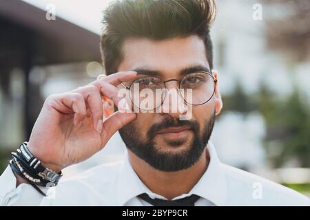 Stilvoll gekleideter indischer Bärtiger geht die Straße hinunter. Stockfoto