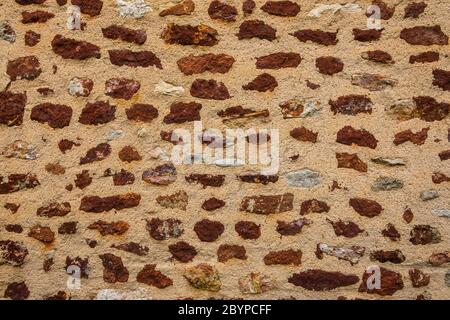 Detail der Mauer in Le Bouchet, die den roten Eisengehalt in dem lokalen Stein zeigt, Brenne, Indre, Frankreich. Stockfoto