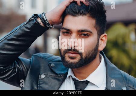 Stilvoll gekleideter indischer Bärtiger geht die Straße hinunter. Stockfoto