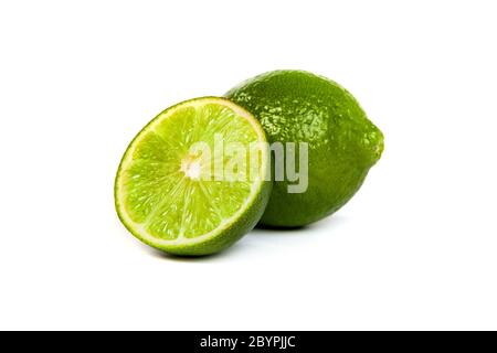 Eine ganze Limette und eine halbe Limette auf weiß Stockfoto