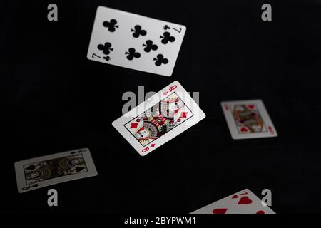 Schwebende Spielkarten auf schwarzem Hintergrund Stockfoto