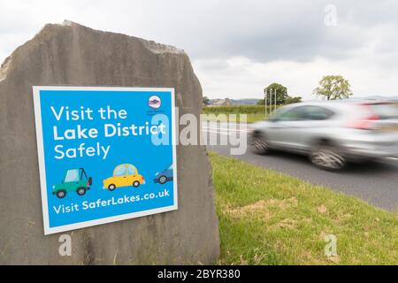 Besuchen Sie das Lake District sicher Schild am Eingang zum Nationalpark direkt vor Kendal. Schild Aufsetzen, wenn Regierung laut Auto Reisen in Großbritannien Stockfoto