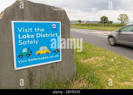 Besuchen Sie das Lake District sicher Schild am Eingang zum Nationalpark direkt vor Kendal. Schild Aufsetzen, wenn Regierung laut Auto Reisen in Großbritannien Stockfoto