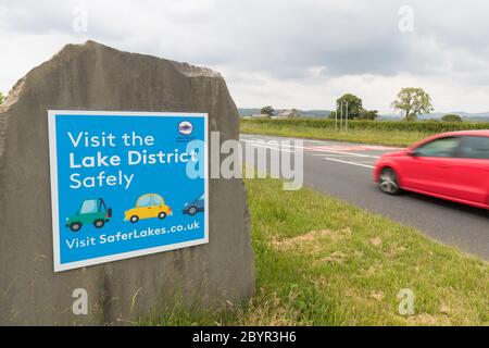 Besuchen Sie das Lake District sicher Schild am Eingang zum Nationalpark direkt vor Kendal. Schild Aufsetzen, wenn Regierung laut Auto Reisen in Großbritannien Stockfoto