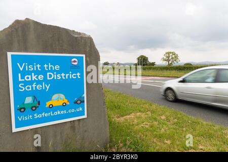 Besuchen Sie das Lake District sicher Schild am Eingang zum Nationalpark direkt vor Kendal. Schild Aufsetzen, wenn Regierung laut Auto Reisen in Großbritannien Stockfoto