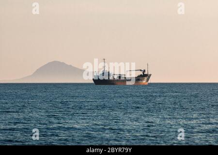 Öltanker segelt auf dem ruhigen blauen Mittelmeer mit Berg im Hintergrund Stockfoto