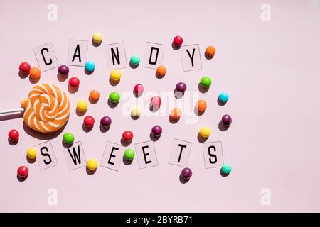 Geburtstagskonzept . Holiday Food Top Ansicht verschiedene süße Bonbons auf rosa Hintergrund. Witzige Dekoration. Minimales Urlaubskonzept. Muster Lutscher, Süßigkeiten Stockfoto