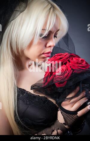 Schwarze Witwe in Trauer mit Blumen mit Schleier Stockfoto