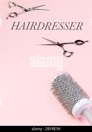 Mehrere Friseurtools. Schere und Haarbürste. Auf einem rosa Hintergrund. Platz für Ihren Text. Ansicht von oben. Hochwertige Fotos Stockfoto