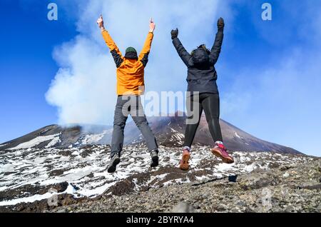 Ein paar Touristen springen auf den Ätna, Sizilien, Italien Stockfoto