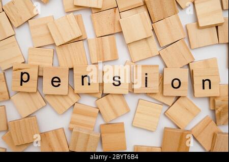 Holz Buchstaben Fliesen Schreibweise Wort PENSION liegend auf einem Haufen von Fliesen Stockfoto