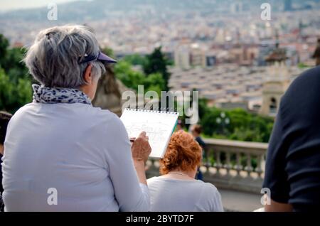 BARCELONA, SPANIEN - 18. MAI 2018. Ältere Frau Künstlerin malt auf einer Straße von Barcelona Stockfoto