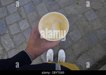 Kaffee zum mitnehmen. Mann hält Pappbecher mit Kaffee auf der Straße. Stockfoto